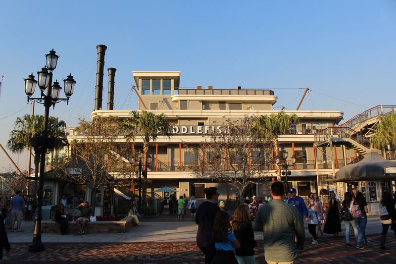 Visitors walking the waterfront promenade at Disney Springs.
