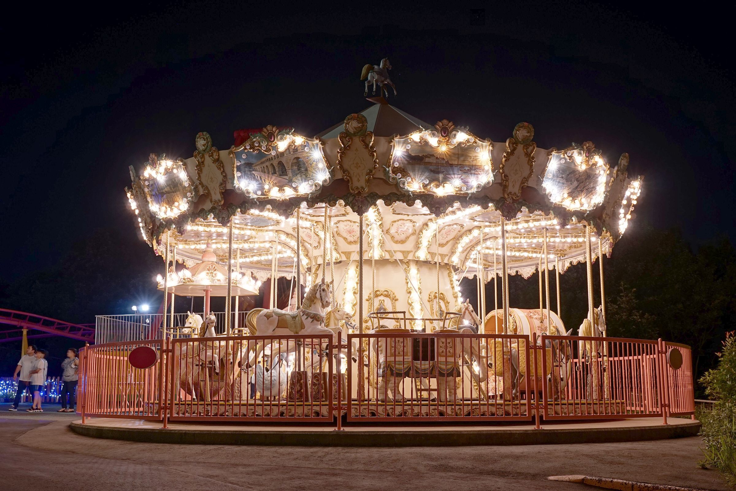 A carousel lit with hundreds of bulbs against a night sky.