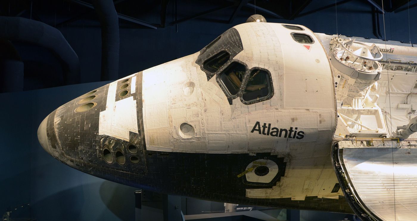 Space Shuttle Atlantis displayed on an angle inside its exhibition hall.