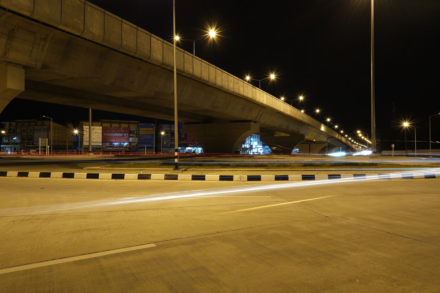 A highway photographed at night, headlights drawn into streaks.