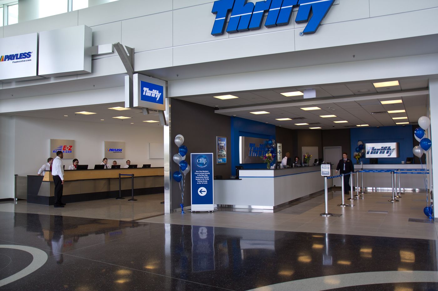 A row of rental car company counters inside an airport facility.
