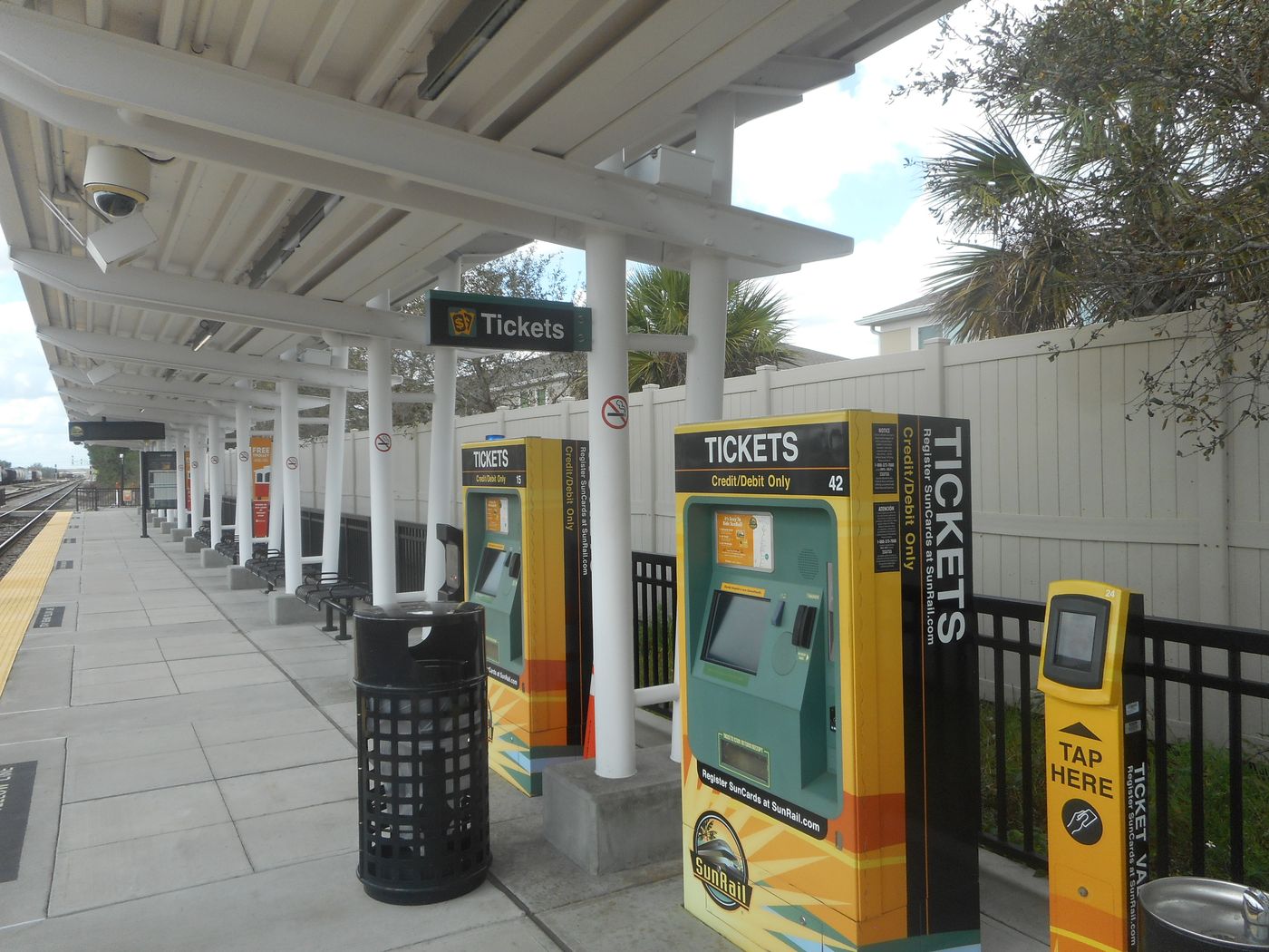 Yellow SunRail ticket vending machines on a covered station platform.