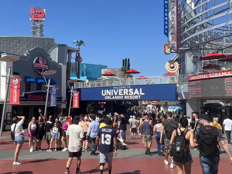 Crowds walking under the Universal Orlando Resort sign at CityWalk.